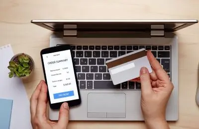 photo of hands over laptop holding a credit card