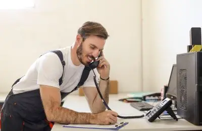 man in overalls on phone with customer