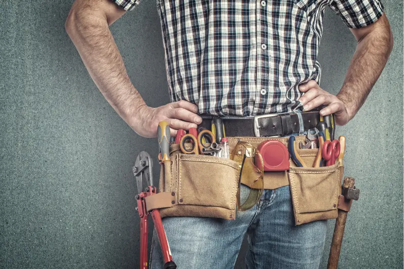 handyman with hands on hips wearing a toolbelt