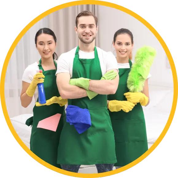 trio of cleaning service professional wearing cleaning aprons and holding various cleaning supplies